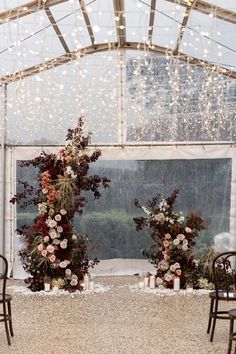 two chairs are set up with flowers and candles