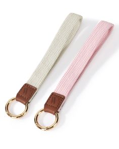 the pink and white strap is attached to a brown leather loop with two gold rings