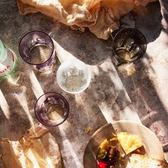 an overhead view of food and drinks on a table with the sun shining through it