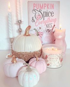 a white pumpkin surrounded by candles and other decorative items in front of a sign that says pumpkin spice everything nice