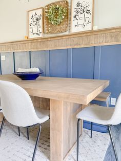 a wooden table with two white chairs and a blue bowl on top of the table