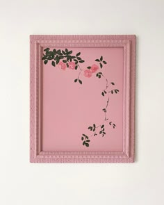 a pink frame with flowers painted on the inside and bottom, hanging on a wall