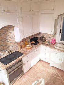 a kitchen with white cabinets and marble counter tops is seen in this image from above