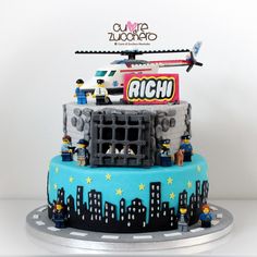 a birthday cake with legos on top and an airplane flying over the city in the background