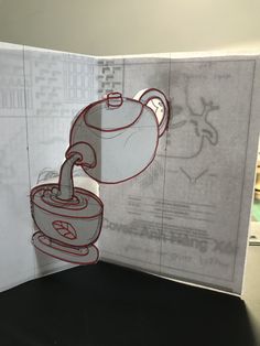 an open book with a drawing of a teapot on the front and back cover