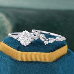 a close up view of a diamond ring on top of a blue velvet cushioned surface