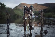 some people are standing in the water and one is carrying something