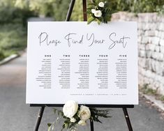 a seating sign with white flowers on it