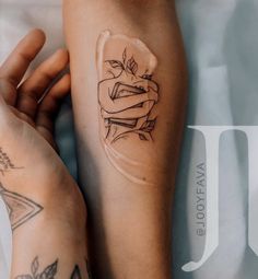 a woman's arm with tattoos on it and a glass vase in the shape of a rose