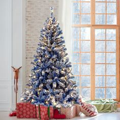 a blue christmas tree with presents under it