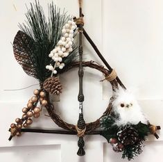 a wreath with pine cones, feathers and other decorations