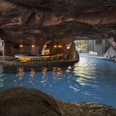 the inside of a cave with a pool and waterfall