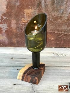 a glass candle holder on a wooden stand