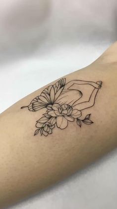 a woman's arm with a flower tattoo on the left side of her body