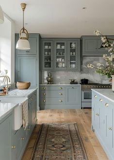 a kitchen with blue cabinets and an area rug in the middle, along with wooden flooring