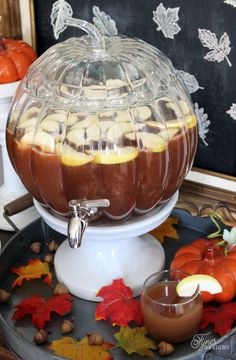 a dessert dish with apples and chocolate in it on a platter next to fall leaves