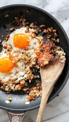 two fried eggs on top of rice in a skillet