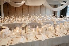 the tables are set with white flowers and candles for an elegant wedding reception or special event