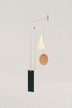 a mobile with two different shapes hanging from it's sides and a round object on the other side