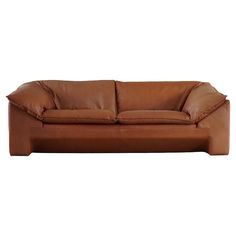 a brown leather couch sitting on top of a white floor