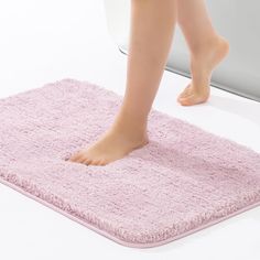 a close up of a person standing on a bath mat with their feet in the water