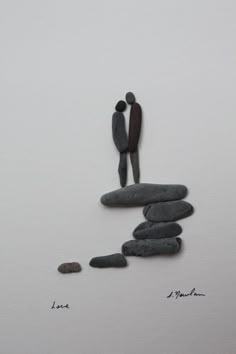 an image of two people standing on rocks with one holding the other's hand