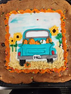 a cookie decorated like a truck with sunflowers and pumpkins in the bed