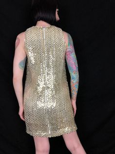 "Dazzling Vintage 1960's Metallic Gold Fully Sequined Mod Cocktail Party Go Go Shift Dress! Features: - gold metallic fully sequined woven fabric on a white acetate body - rounded neckline - darts at bust - straight A-line shift dress shape - gold metallic piping trim - 2 metal zipper closures up back; 1 on the outer sequin body, and the 2nd zipper for the lining - fully lined in a white acetate - extremely well made! The hidden double zipper feature shows a lot of detail went into making this p Gold Party Mini Dress With Contrast Sequin, Gold Mini Dress With Contrast Sequin, Sequin Dress 70’s, Gold Shimmer Sleeveless Mini Dress, Lee Jordan, 1960s Sequin Dress, Jordan New, Newest Jordans, Rounded Neckline