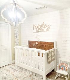 a baby's room with a crib, rocking chair and lamp