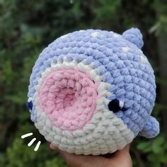 a crocheted blue and white stuffed animal with a pink eye on it's face