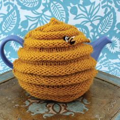 a knitted tea pot cover sitting on top of a tray