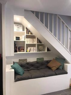 a room that has some bookshelves and pillows on the floor in it,