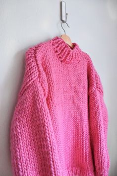 a pink sweater hanging on the wall