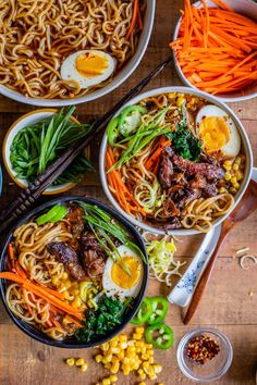 three bowls with noodles, carrots and meat in them next to chopsticks