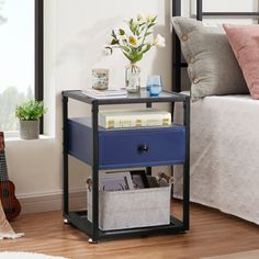 a bed room with a neatly made bed and a small blue drawer next to it