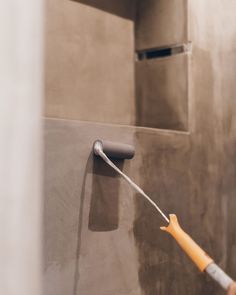 a person using a paint roller on the side of a wall