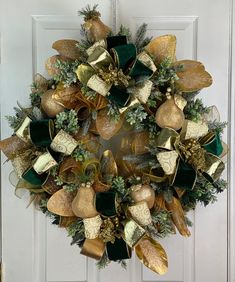 a christmas wreath with gold and green decorations hanging on the front door to give it a festive touch