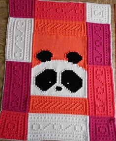 a crocheted panda bear is on the floor