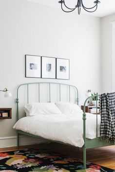 a bedroom with a bed, rug and pictures on the wall