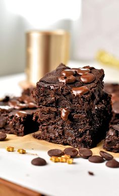 two brownies stacked on top of each other with chocolate chips scattered around the edges