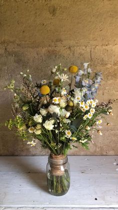 a vase filled with lots of white and yellow flowers