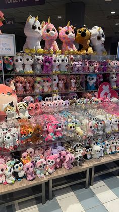 many small stuffed animals are on display in a store