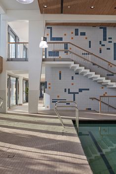 an indoor swimming pool with stairs and tiled walls