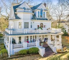 a large white house with lots of windows and balconies on the second floor