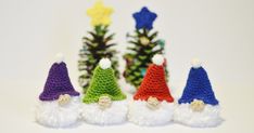 small crocheted gnomes lined up in front of pine cones