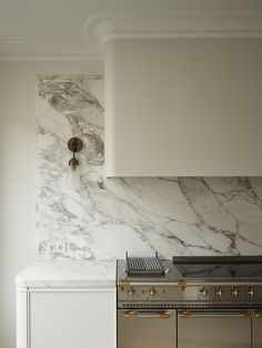 a stove top oven sitting inside of a kitchen next to a wall mounted range hood