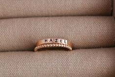 Create your own beautiful set of name rings to show off the people closest to your heart! So simply pretty! Our 3mm high quality 14k Gold-Filled band rings fit one date, name or word in your choice of font. Our rings stack beautifully together, so purchase up to 3 name band rings total for one finger. Please keep the total characters per ring to around 20 max. Up to 3 name ring bands with two spacers will fit on one finger, and we recommend sizing to the next whole size up if you are stacking 3 rings. Please read the sizing details first in the DETAILS section below. D E T A I L S 14k Gold Filled Name Band Rings: Whole US Sizes: 4 - 10 Option to add spacer rings Lowercase tiny script font or UPPERCASE Arial Choose natural or darkened lettering Fit one name, date or word per ring Stamped by Custom Name Stackable Rings In 14k Gold For Anniversary, Custom Name 14k Gold Stackable Rings For Anniversary, 14k Gold Stackable Rings With Custom Name For Anniversary, Custom Name Stackable Rose Gold Promise Rings, Custom Name Engraved Ring In Rose Gold For Promise, Personalized Rose Gold Stackable Rings For Promise, Personalized Rose Gold Stackable Rings With Round Band, Custom Name Engraved Rose Gold Ring For Promise, Personalized Rose Gold Stackable Rings