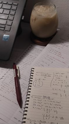 a notebook and pen sitting on top of a table next to a computer keyboard, mouse and calculator