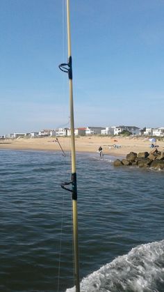 there is a boat in the water and people are out on the beach behind it