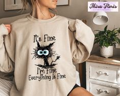 It's Fine I'm Fine Everything is Fine Sweatshirt, Introvert Sweatshirt, Sarcastic Sweat, I'm Fine, Everything is Fine T-Shirt, Mental Shirt Unisex Sizing Across All Products Discover your perfect fit with our size and color guides, available in the product photo gallery. How to Order from Our Etsy Store Excited about our offerings? Follow these easy steps to make them yours: 1. Explore: Browse our curated collection and find products that resonate with your style. Our attention to detail shines through in every piece. 2. Select: Found something you love? Click on it for more details like size, color, and personalization options. 3. Customize: Pick your preferences from the dropdown menus. For personal touches, use the provided text box for your specifications. 4. Add to Cart: Once you're s Cat Grumpy, Funny Animal Shirts, Sarcasm Shirts, Cozy Cat, Ew People, Cute Black Cat, Cat Lover Shirt, Lazy Cat, I'm Fine